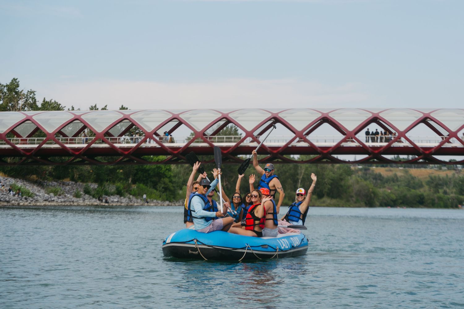 A group of friends enjoying their float along the bow river as they head towards downtown calgary.